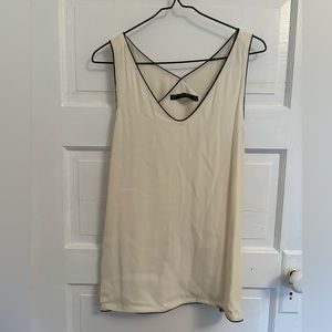 Never worn cream colored sleeveless shirt with black trim.